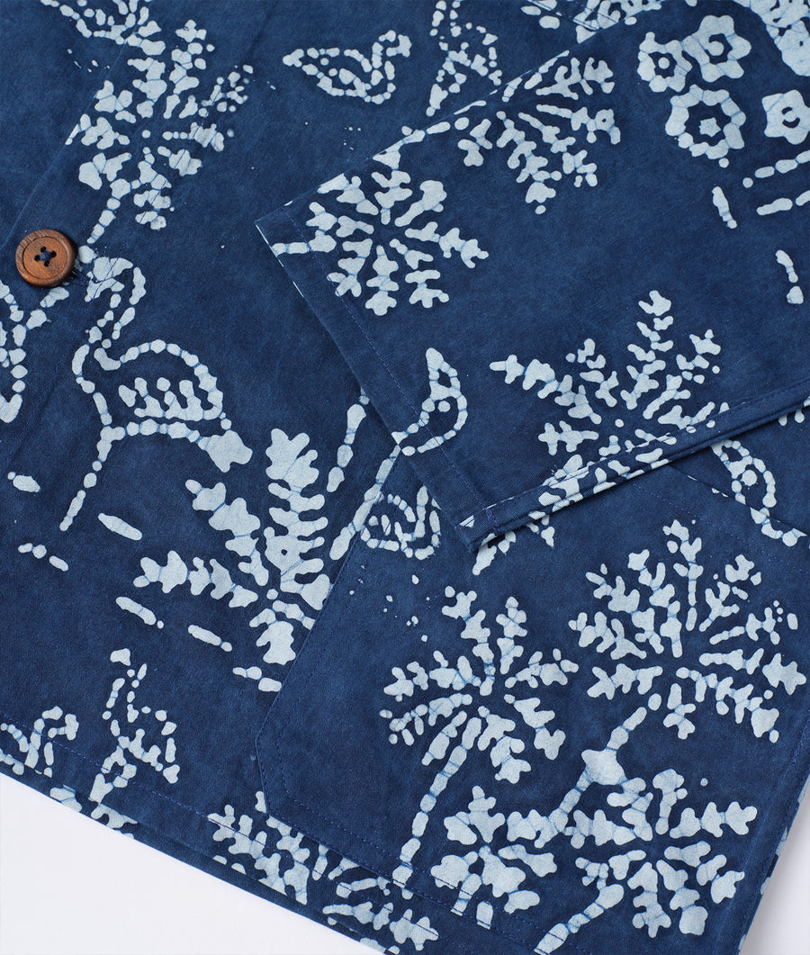A close-up detail shot of a patterned navy blue and white organic cotton fabric with floral and snowflake-like designs - Industry of All Nations