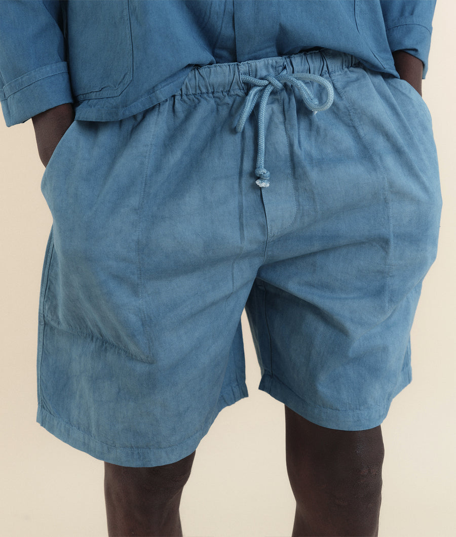Close-up of model's lower body wearing light blue organic cotton drawstring shorts - Industry of All Nations