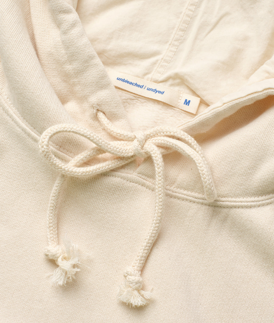 A close-up detail shot of an unbleached, undyed cotton garment with a drawstring and cord tie closure - Industry of All Nations