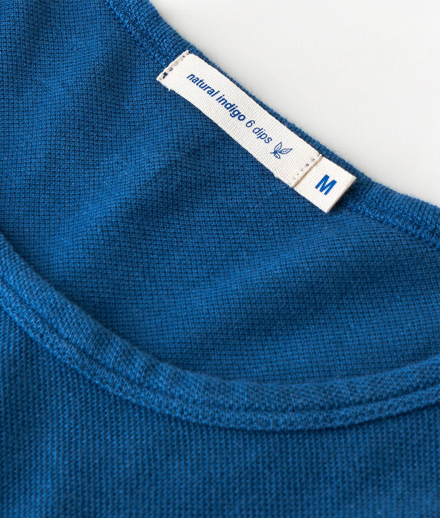 Detail shot of a teal blue knit pullover sweater from Industry of All Nations.