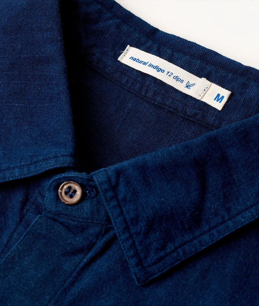 Detail shot of a navy blue button-down shirt with a "Natural Indigo 12 dips" label - Industry of All Nations