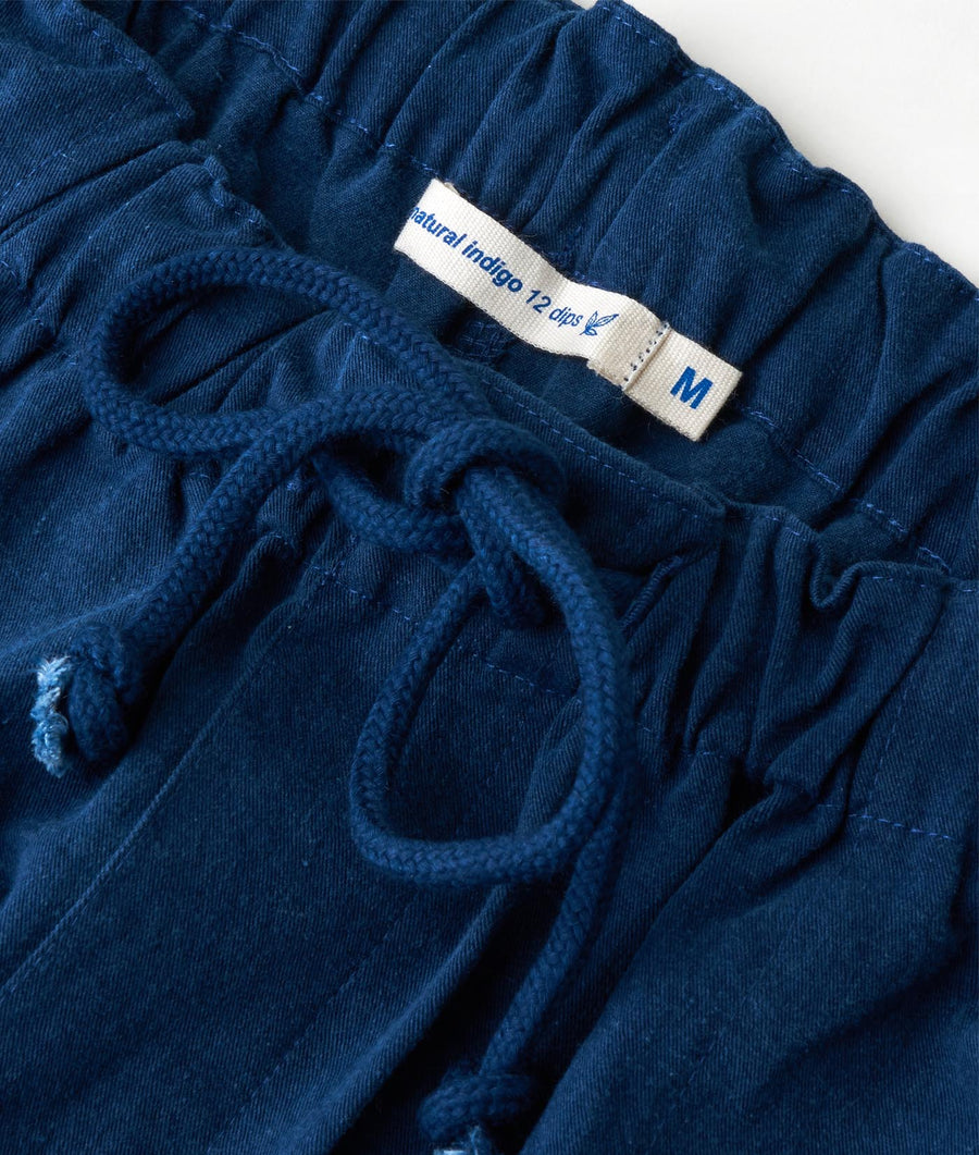 Detail shot of a navy blue pair of 100% organic cotton pants with drawstring waist and "Natural Indigo" label - Industry of All Nations