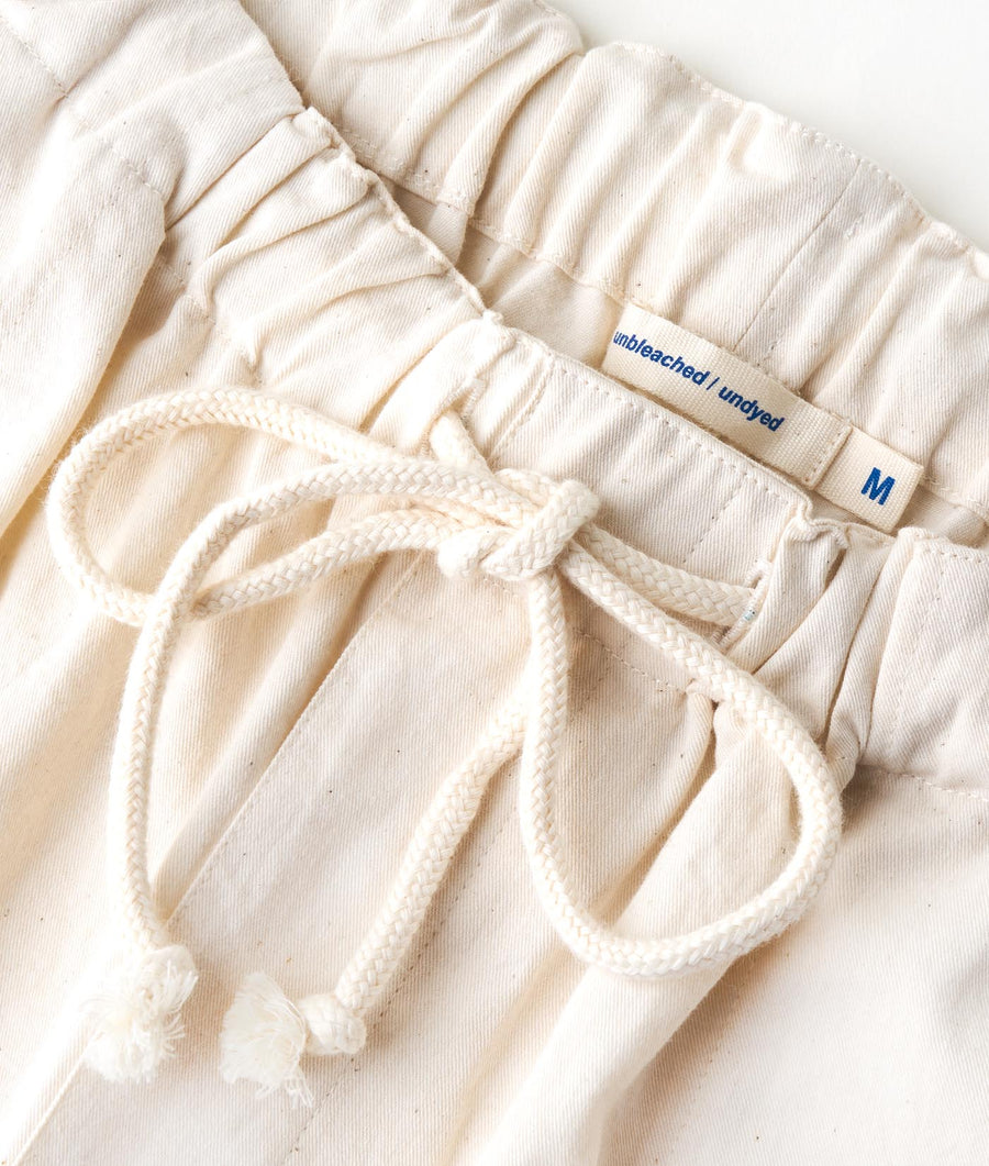 Flat lay of an off-white, unbleached, undyed cotton bottoms with drawstring waist - Industry of All Nations
