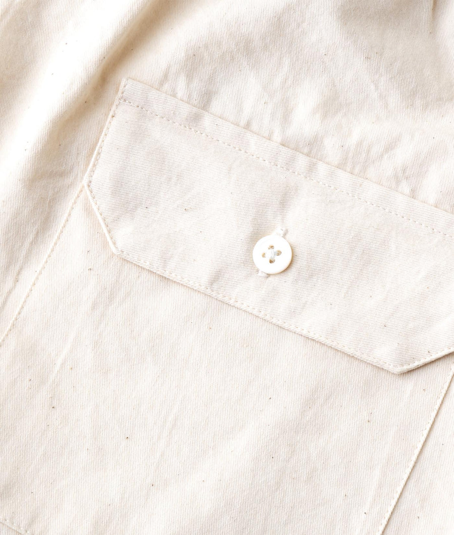 White cotton jacket with a single button closure, displayed as a flat lay - Industry of All Nations