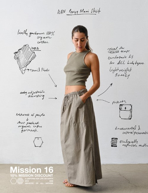 A woman stands against a white wall wearing IOAN Iron 4 tank top and matching Ponya Skirt. Hand-drawn text and sketches surround her, with Mission 16 branding at the bottom left.