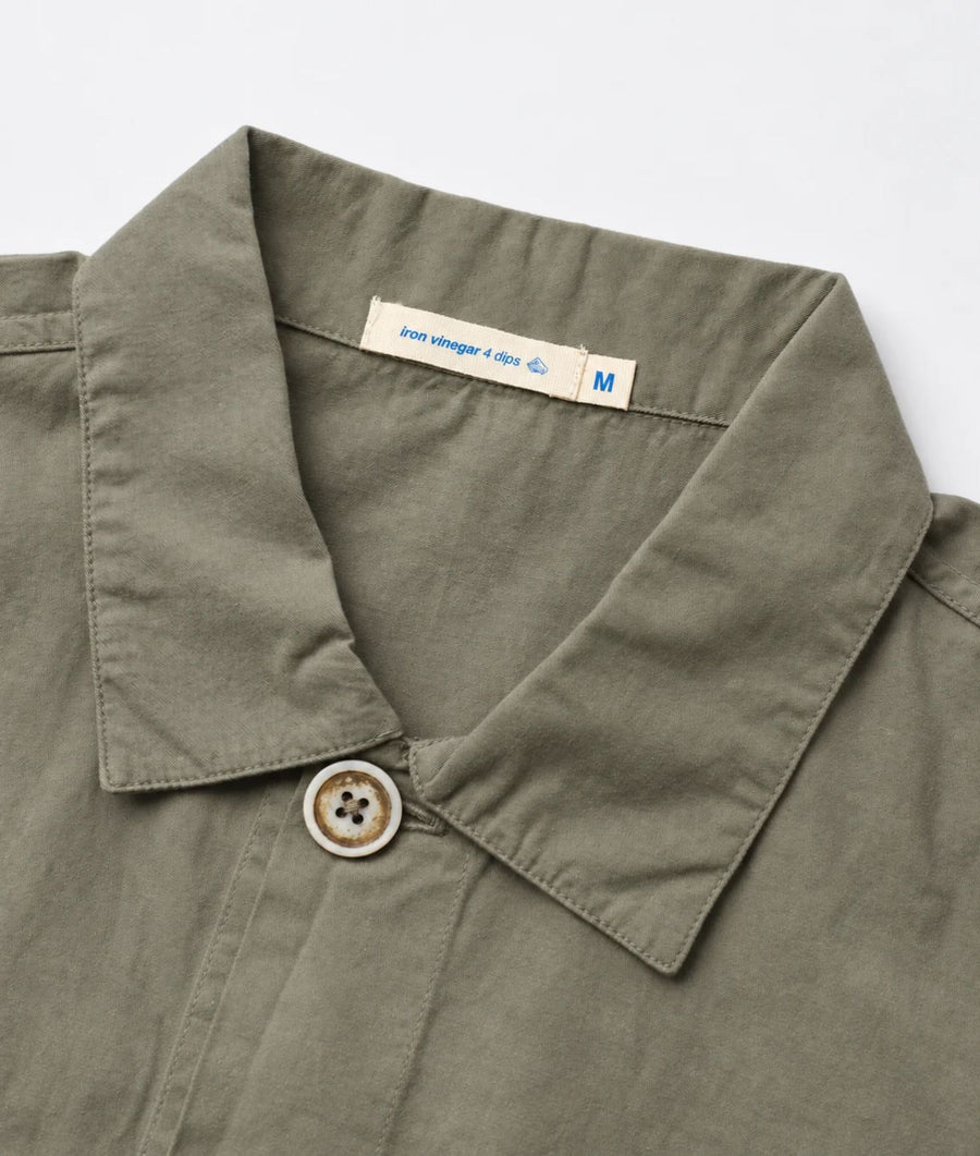 Close-up of an olive green collared shirt with a buttoned collar and a visible neck label reading 'love vintage a day M'.