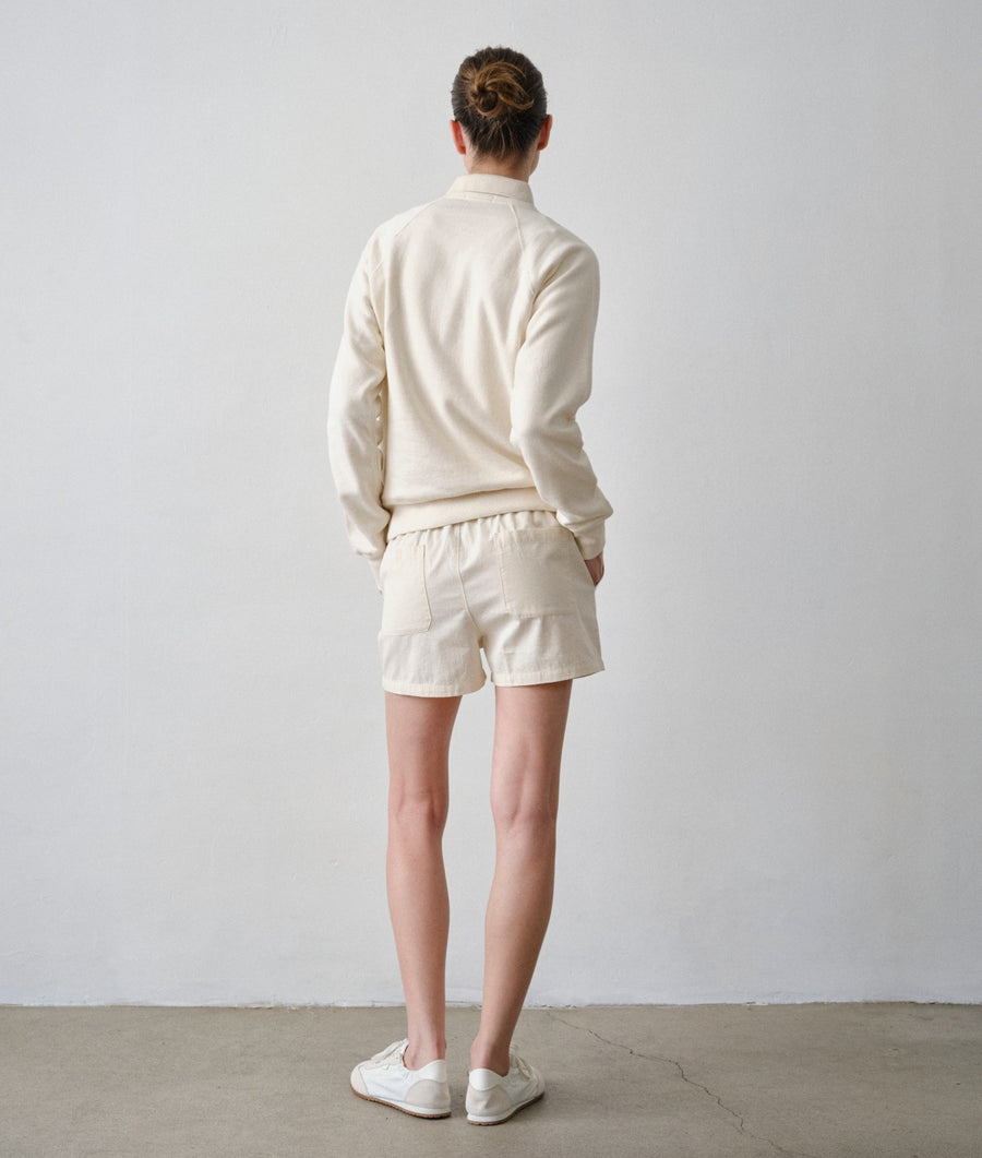 Back view of a woman wearing the IOAN Ponya Shorts and Pocket Sweatshirt in Undyed.