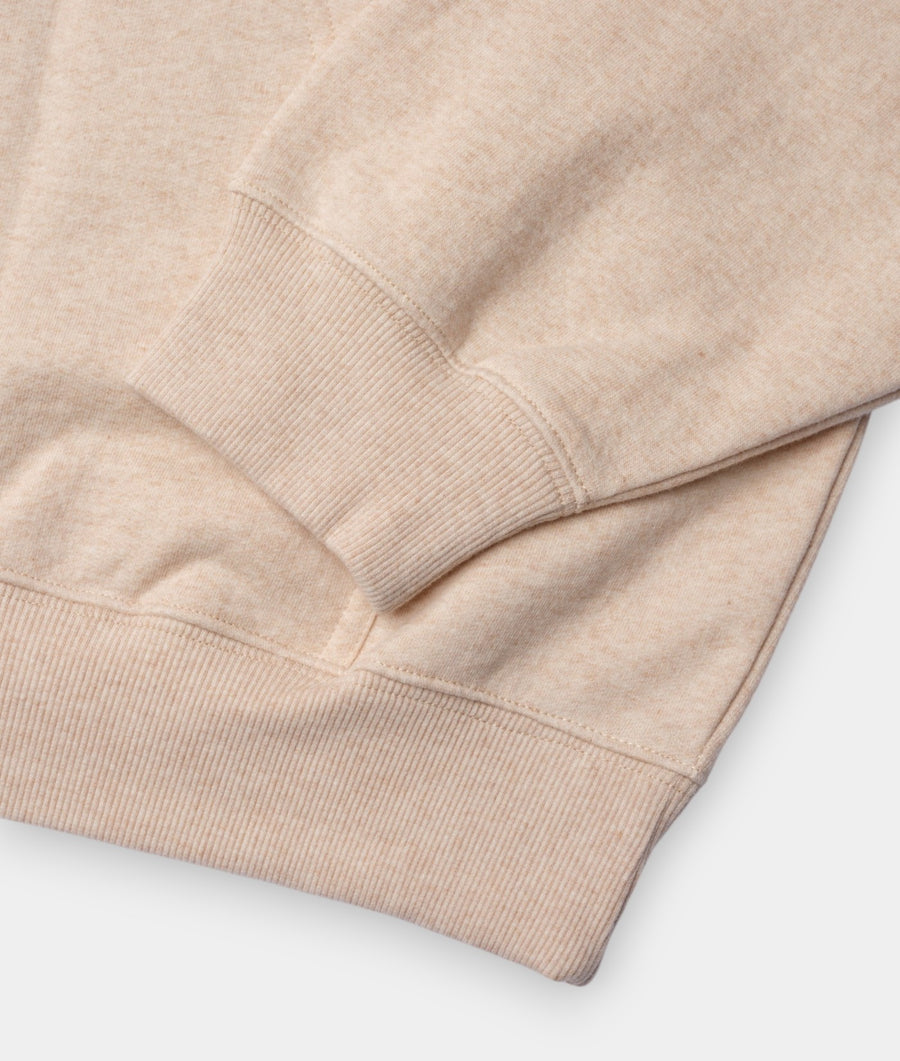 A close-up view of the ribbed cuff and hem details of a beige cotton hoodie, displayed in a flat lay - Industry of All Nations