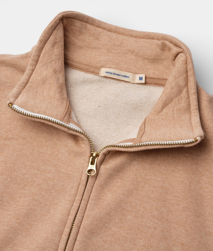 Flat lay detail shot of a beige cotton zip-up jacket with a "native brown cotton" label - Industry of All Nations