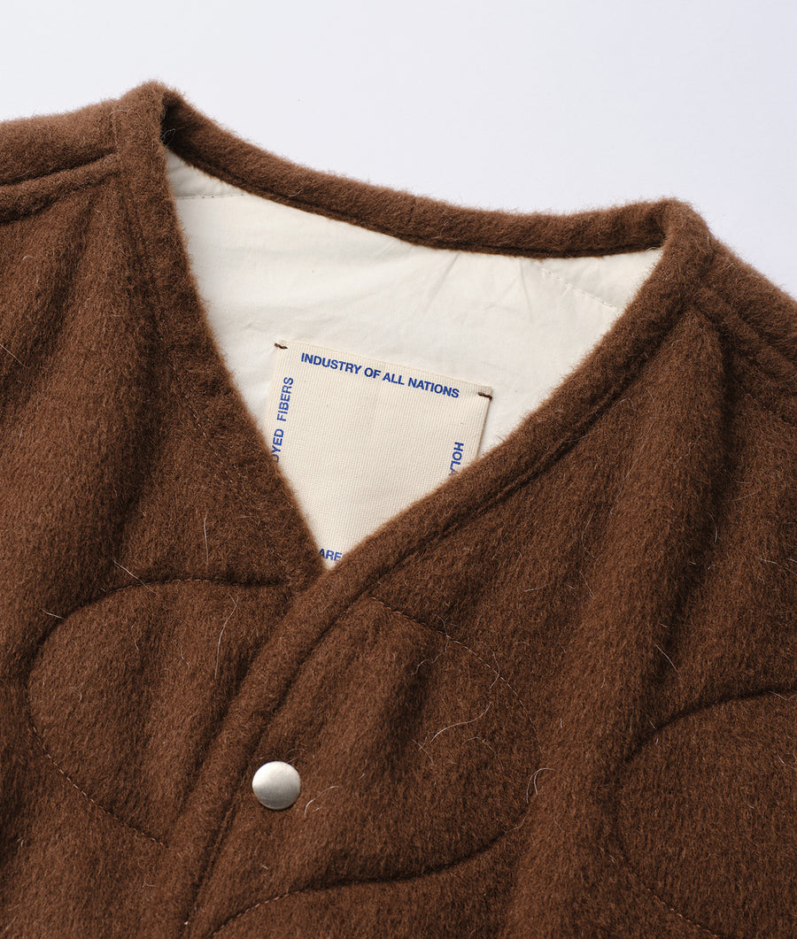 A close-up image of a brown, fuzzy wool garment from the Industry of All Nations sustainable apparel brand.