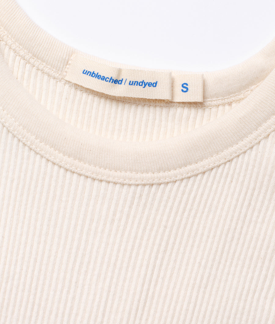 Detail shot of an unbleached, undyed cotton t-shirt with a small 'S' tag - Industry of All Nations