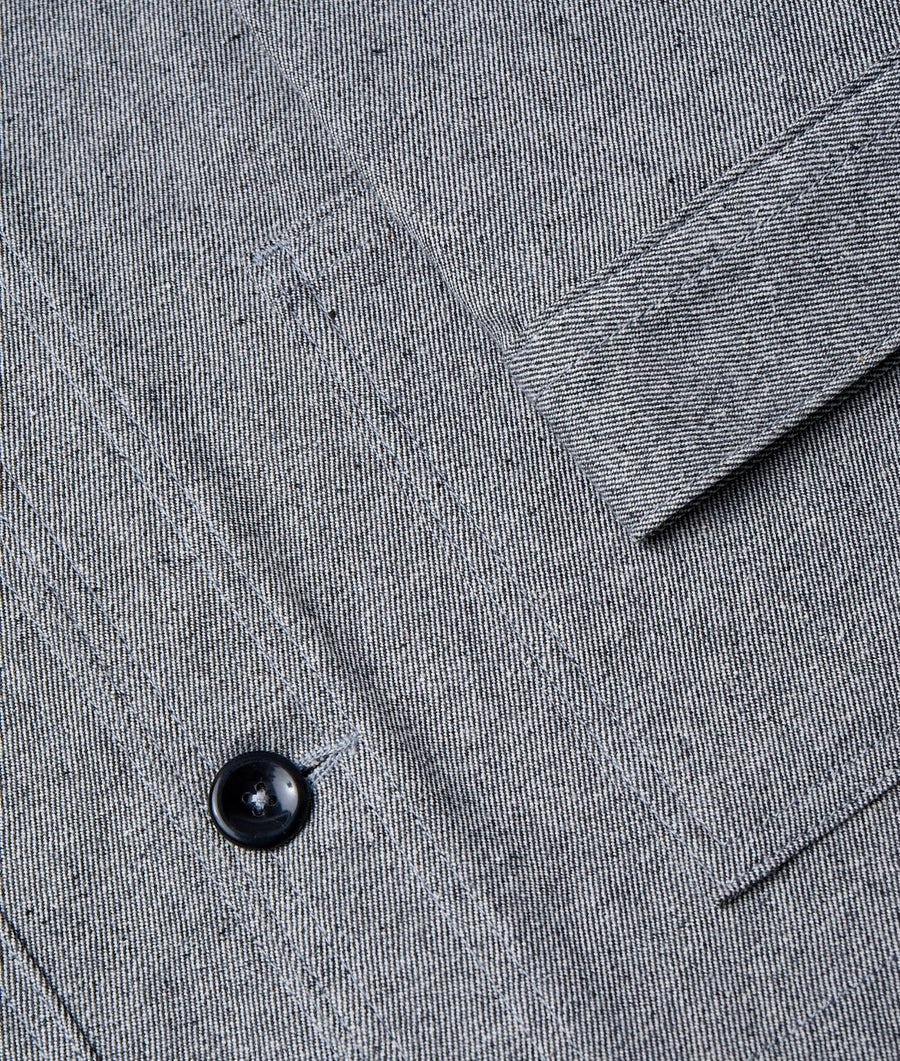 Detail shot of a gray organic cotton garment with a black button - Industry of All Nations