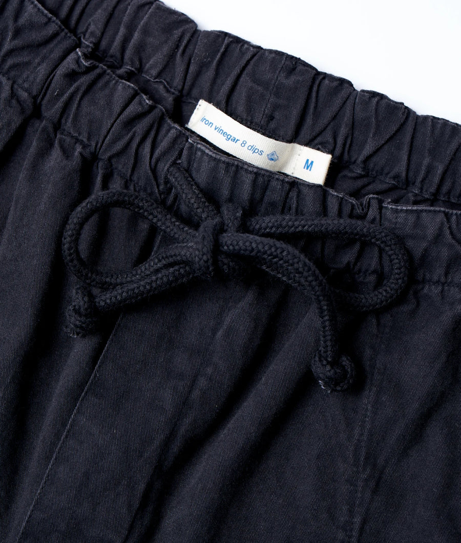 Detail shot of a black organic cotton drawstring waist pant from Industry of All Nations.