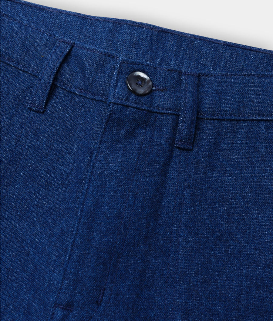 Detail shot of a pair of dark blue denim jeans with a button closure - Industry of All Nations