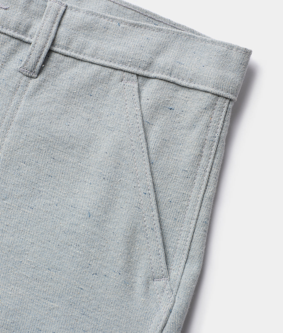 Detail shot of a pair of light gray cotton slacks with visible stitching and pleats - Industry of All Nations