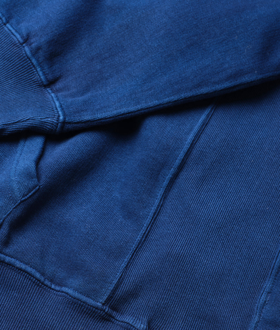 Close-up detail shot of a deep blue organic cotton sweatshirt with ribbed cuffs and hem - Industry of All Nations