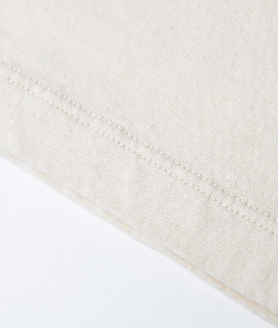 Close-up detail shot of a white organic cotton garment with tightly stitched seam - Industry of All Nations