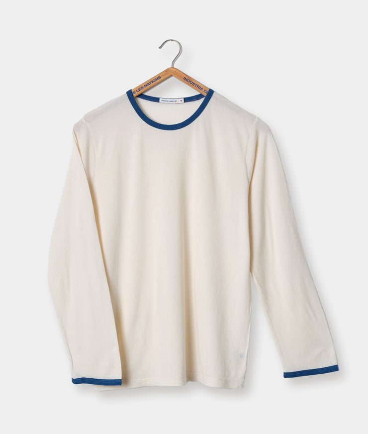 A longsleeve beige and blue ringer t-shirt hanging on a wooden hanger, with the blue collar and cuffs contrasting against the main beige fabric.