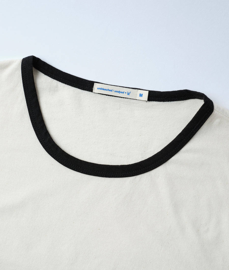 Detail shot of a white organic cotton t-shirt with black trim - Industry of All Nations