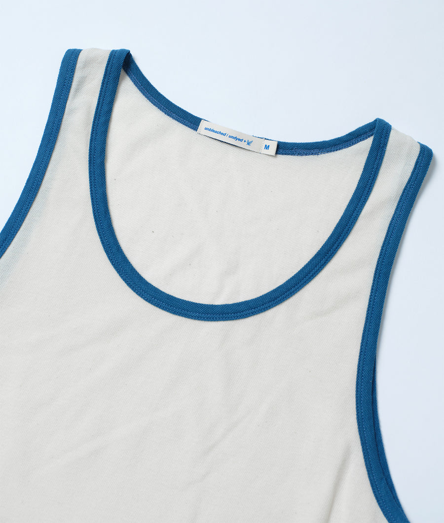 Cream-colored organic cotton tank top with blue trim, displayed in a flat lay shot - Industry of All Nations