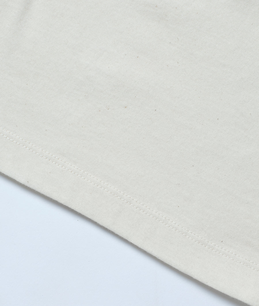 Detail shot of a white organic cotton fabric with stitching - Industry of All Nations
