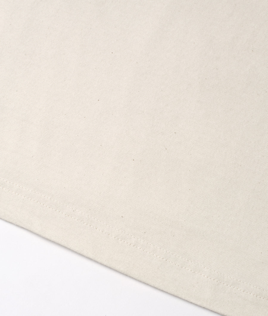Flat lay shot of off-white organic cotton fabric with subtle texture - Industry of All Nations