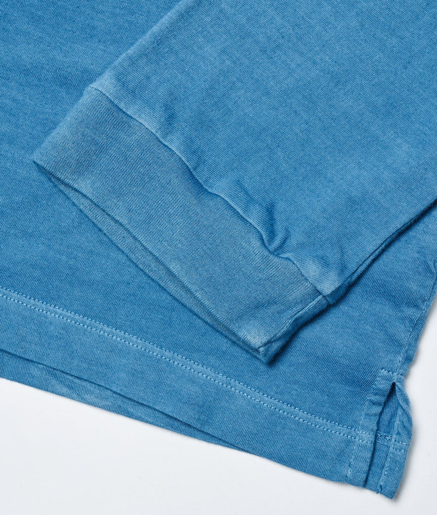 Blue organic cotton t-shirt in a flat lay shot, displaying the fabric texture and detail - Industry of All Nations