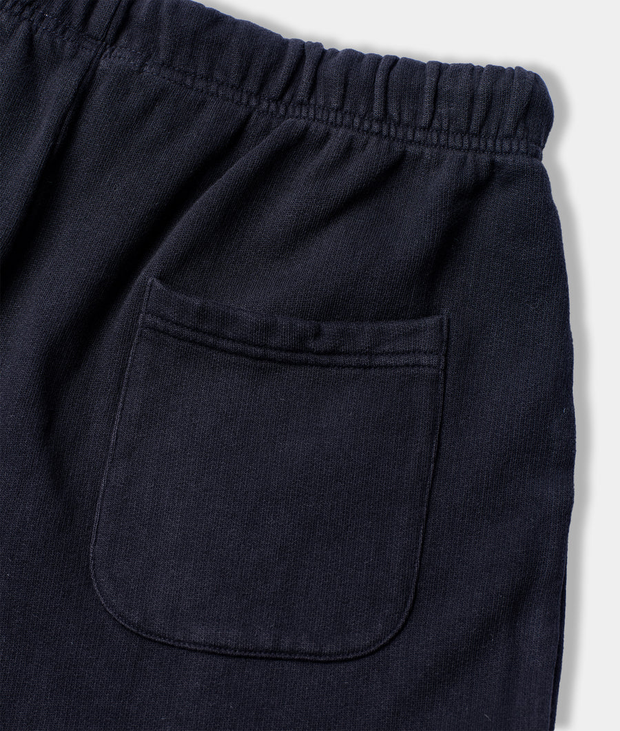 Close-up image of navy blue cotton pants with an elastic waistband and a single pocket detail - Industry of All Nations