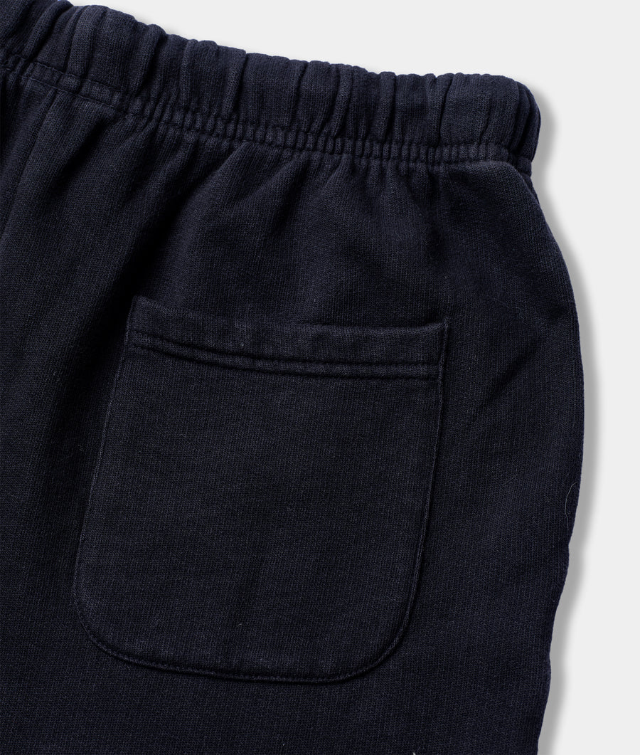 Close-up of the black organic cotton pocket on the front of a pair of IOAN navy blue sweatpants - Industry of All Nations