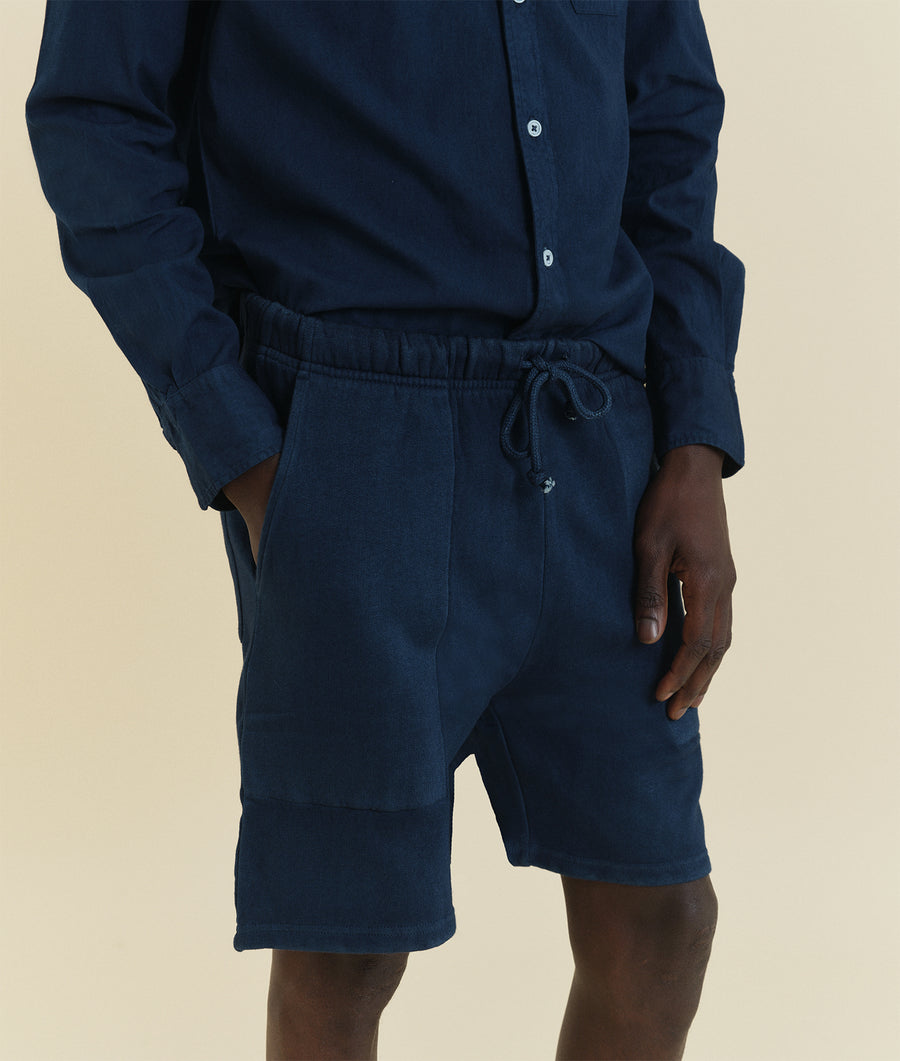 A close-up view of dark navy blue drawstring shorts worn by a model - Industry of All Nations