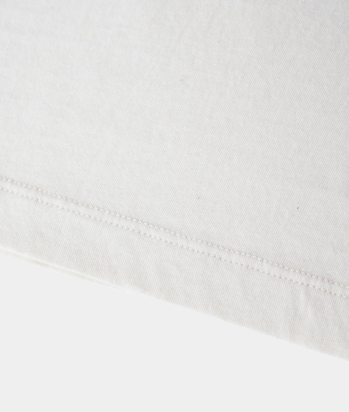 Close-up of a white cotton fabric with a neat hemstitch along the bottom edge.