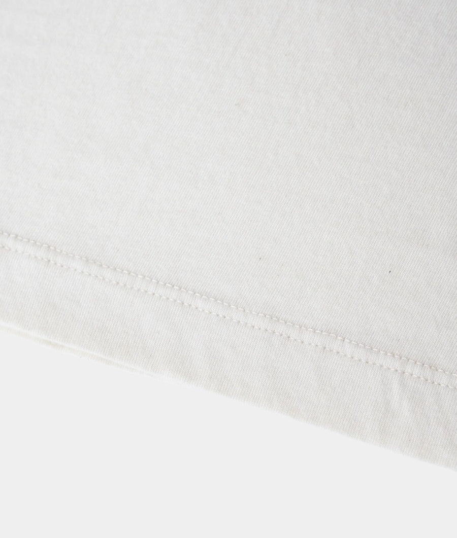 Close-up of a white cotton fabric with a neat hemstitch along the bottom edge.