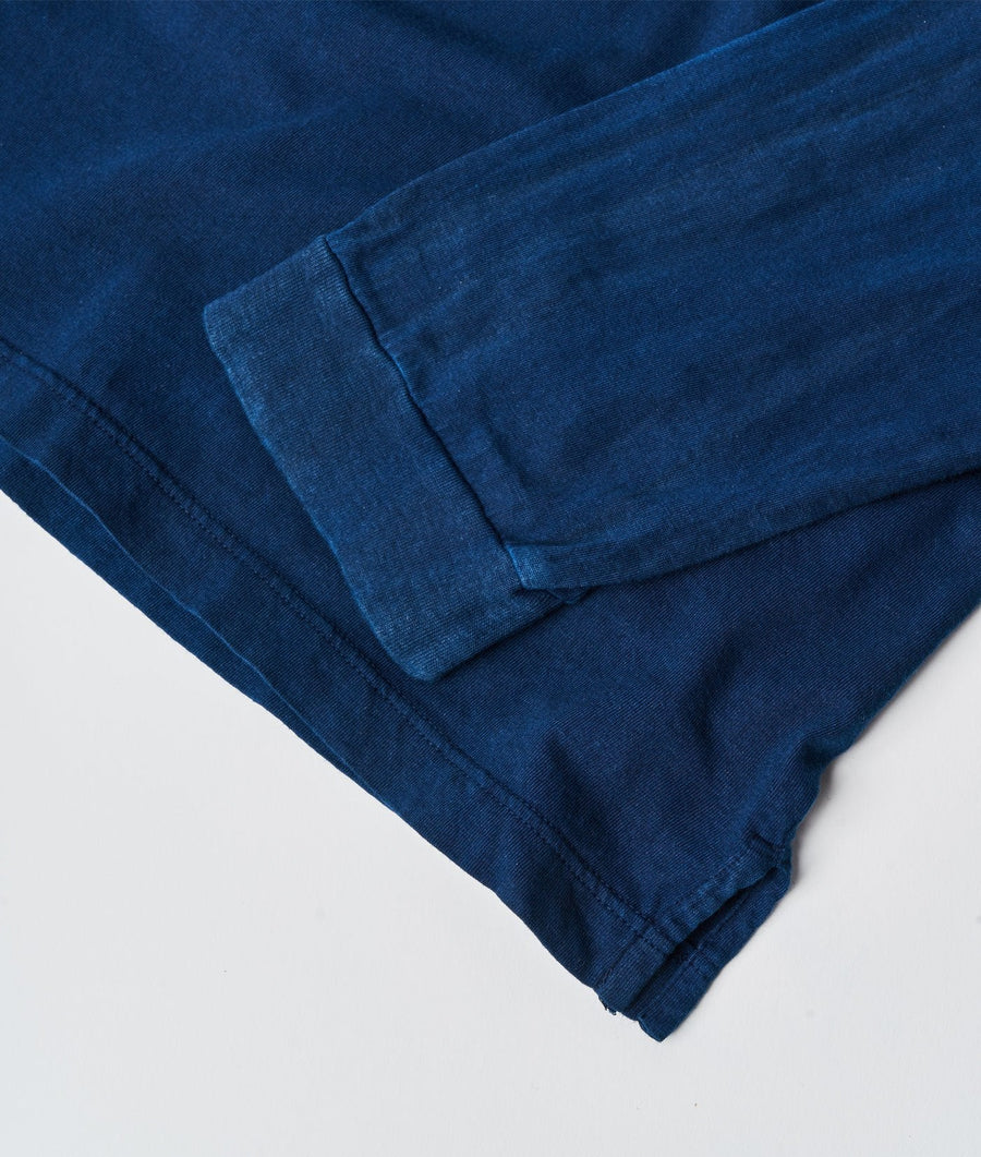 Flat lay shot of a dark blue denim fabric with folds and creases showing the texture and weave - Industry of All Nations