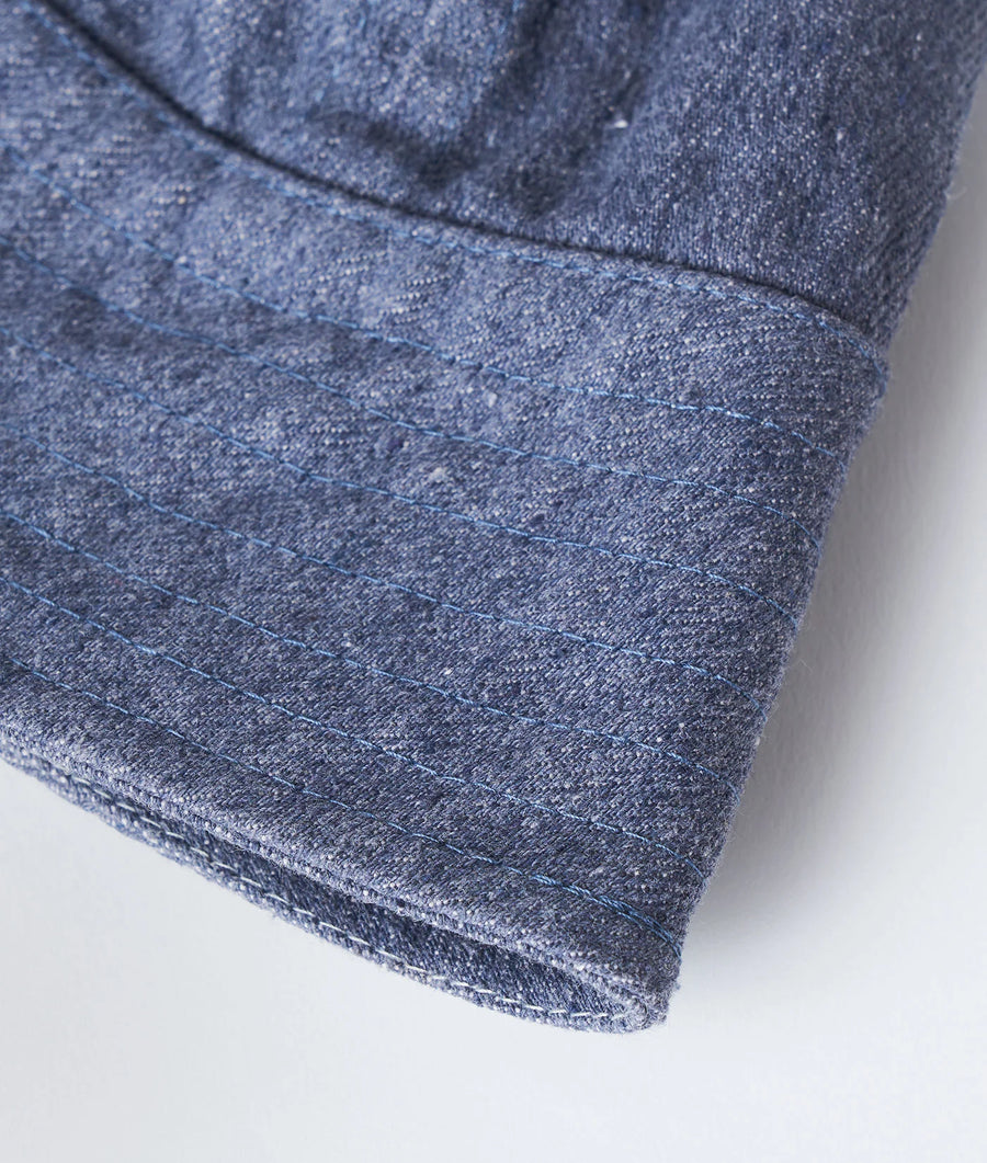 Detail shot of a dark blue denim garment with visible stitching and texture - Industry of All Nations