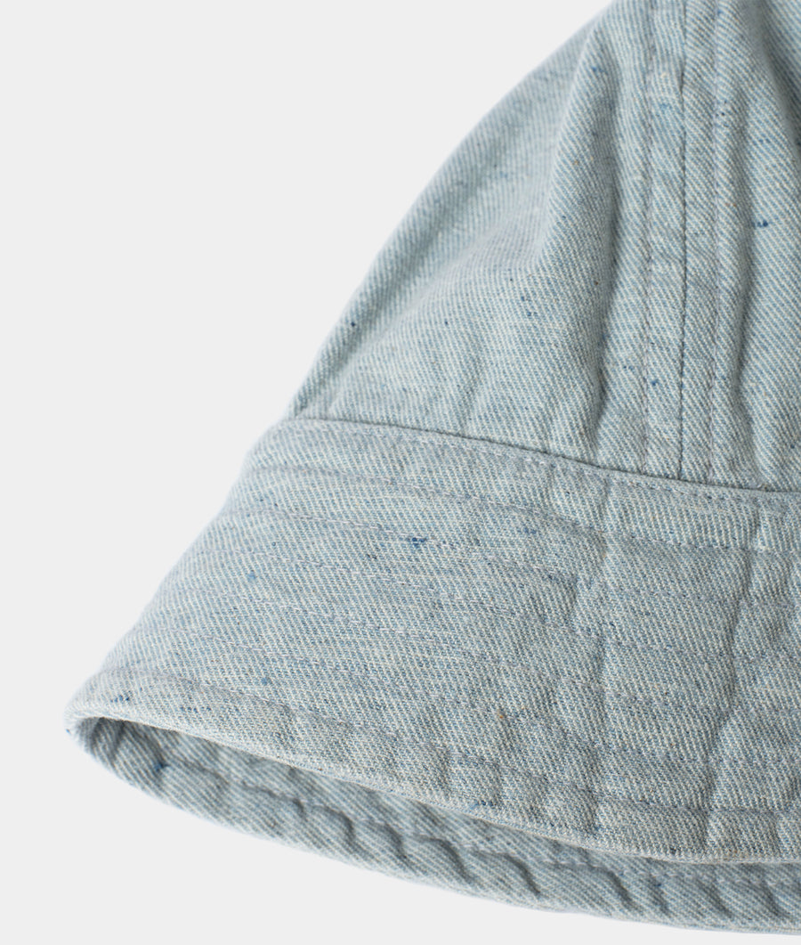 Close-up of a wrinkled, light blue denim skirt displaying the fabric texture and seam details - Industry of All Nations