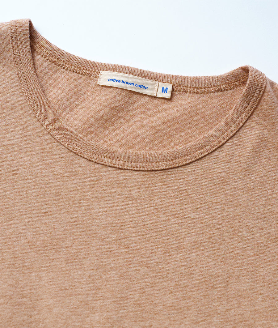 Detail shot of a tan brown cotton t-shirt with a size M tag on the neckline - Industry of All Nations