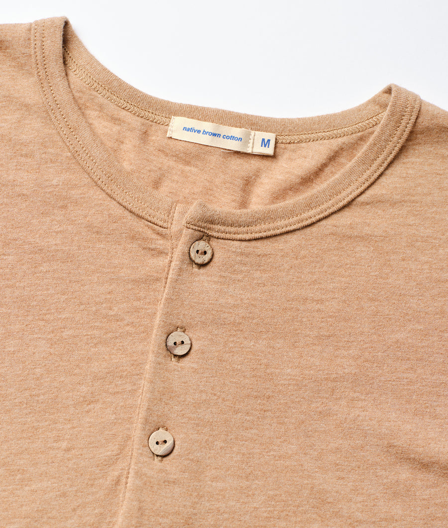 A medium-sized beige button-down shirt made of native brown cotton, displayed as a close-up detail shot of the garment - Industry of All Nations