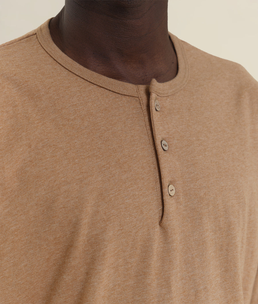 A close-up detail shot of a tan organic cotton crewneck pullover sweater with button placket - Industry of All Nations