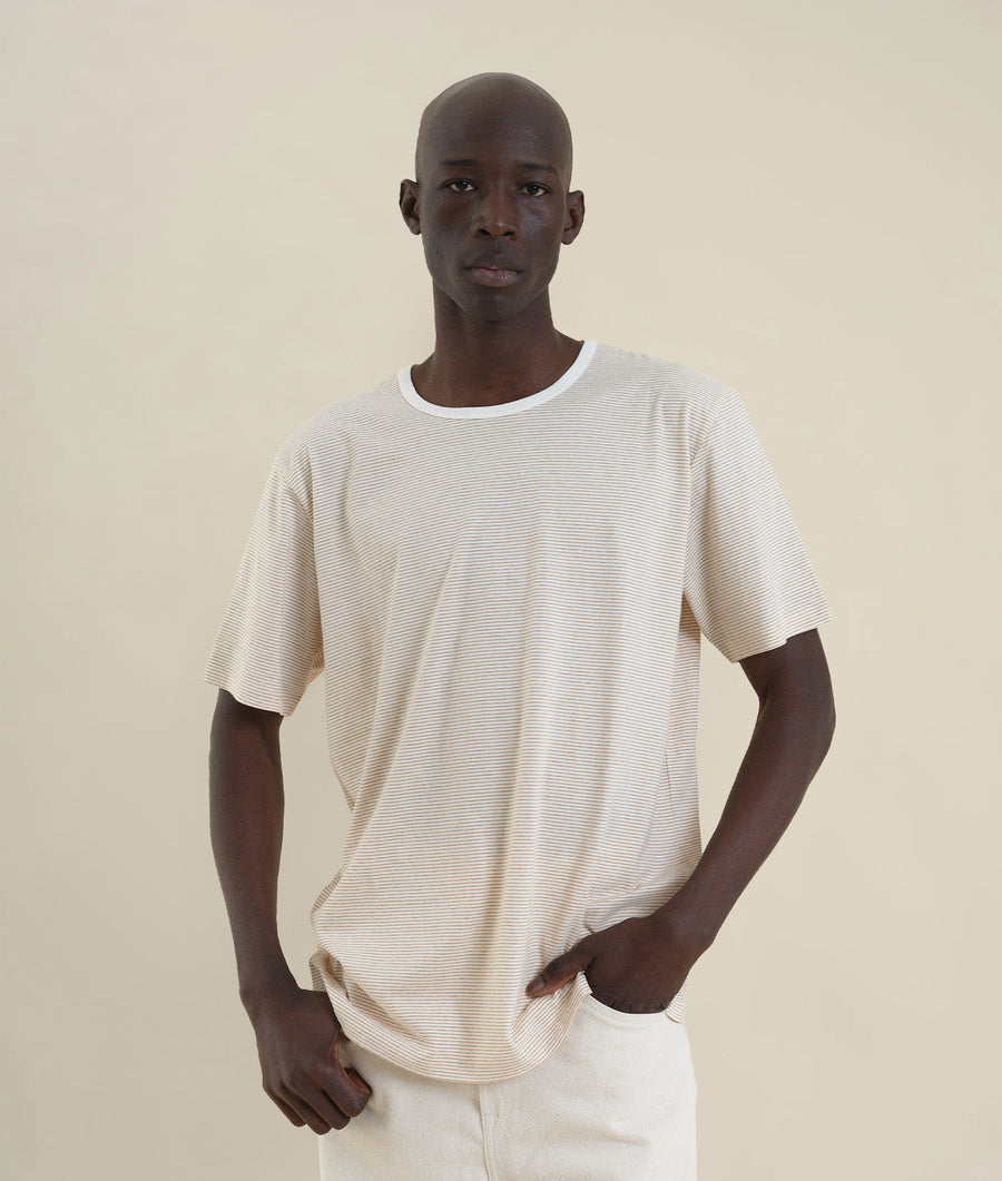 Portrait of a man wearing a white and beige striped t-shirt - Industry of All Nations