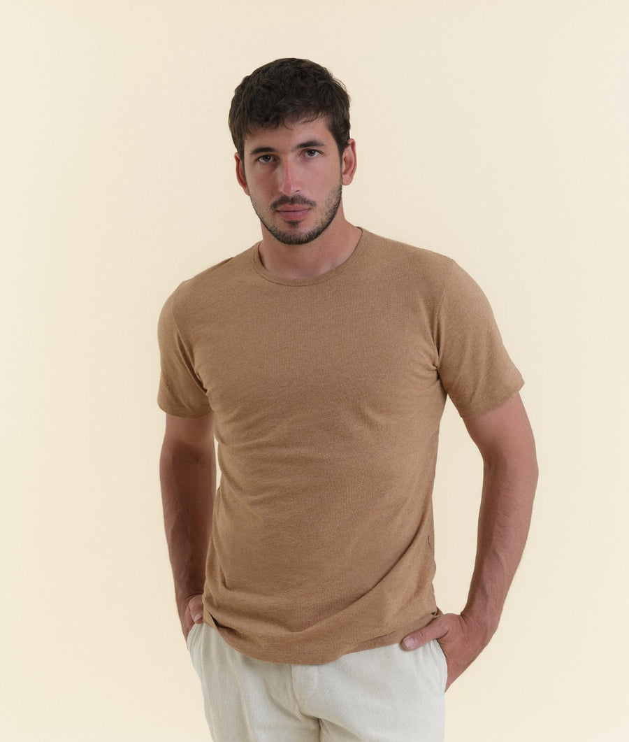 A man wearing a beige t-shirt from Industry of All Nations