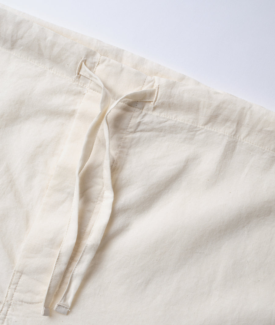 Detail shot of a cream-colored, organic cotton garment - Industry of All Nations
