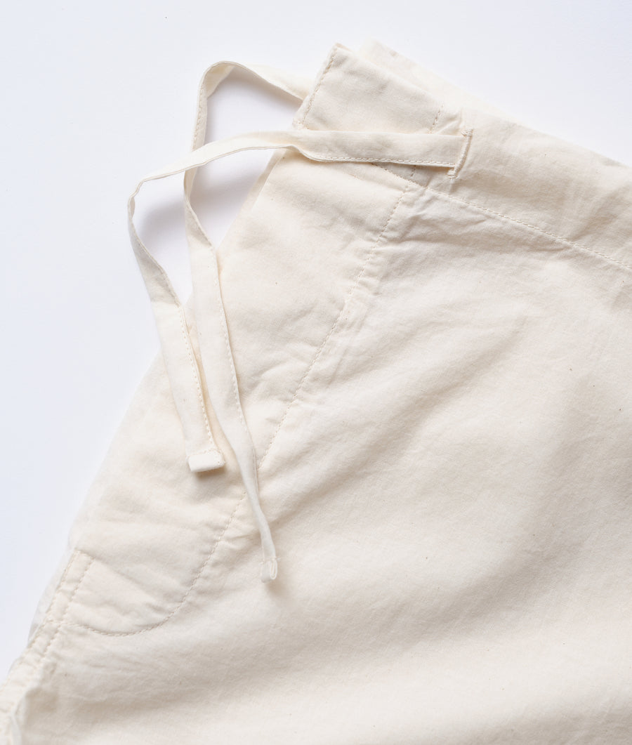 Closeup of a cream-colored drawstring waist cotton pant displayed on a flat surface - Industry of All Nations
