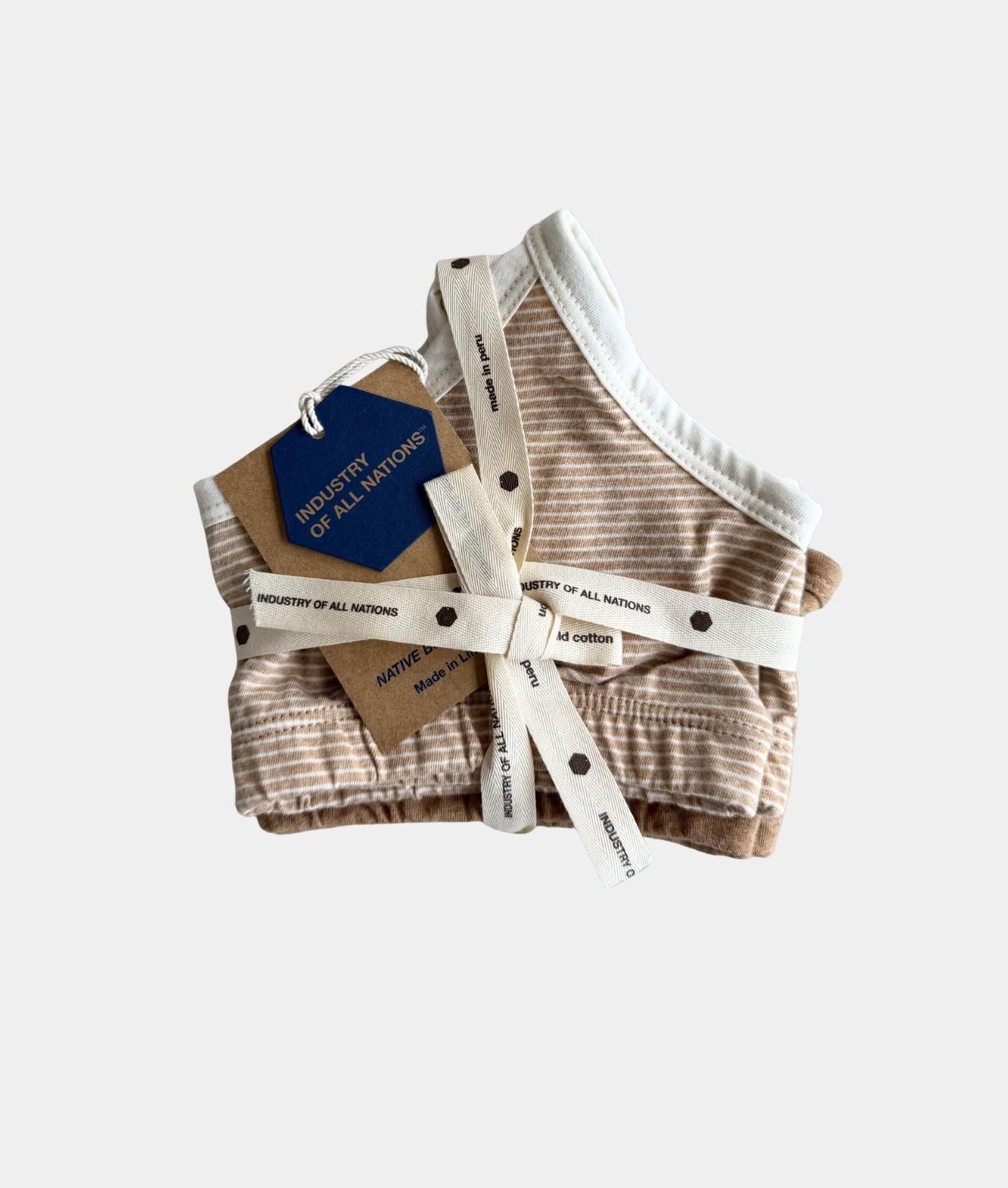 A folded striped knit pet harness in beige and brown, tied with a white ribbon and accompanied by a blue and kraft paper hangtag, on a light gray background.