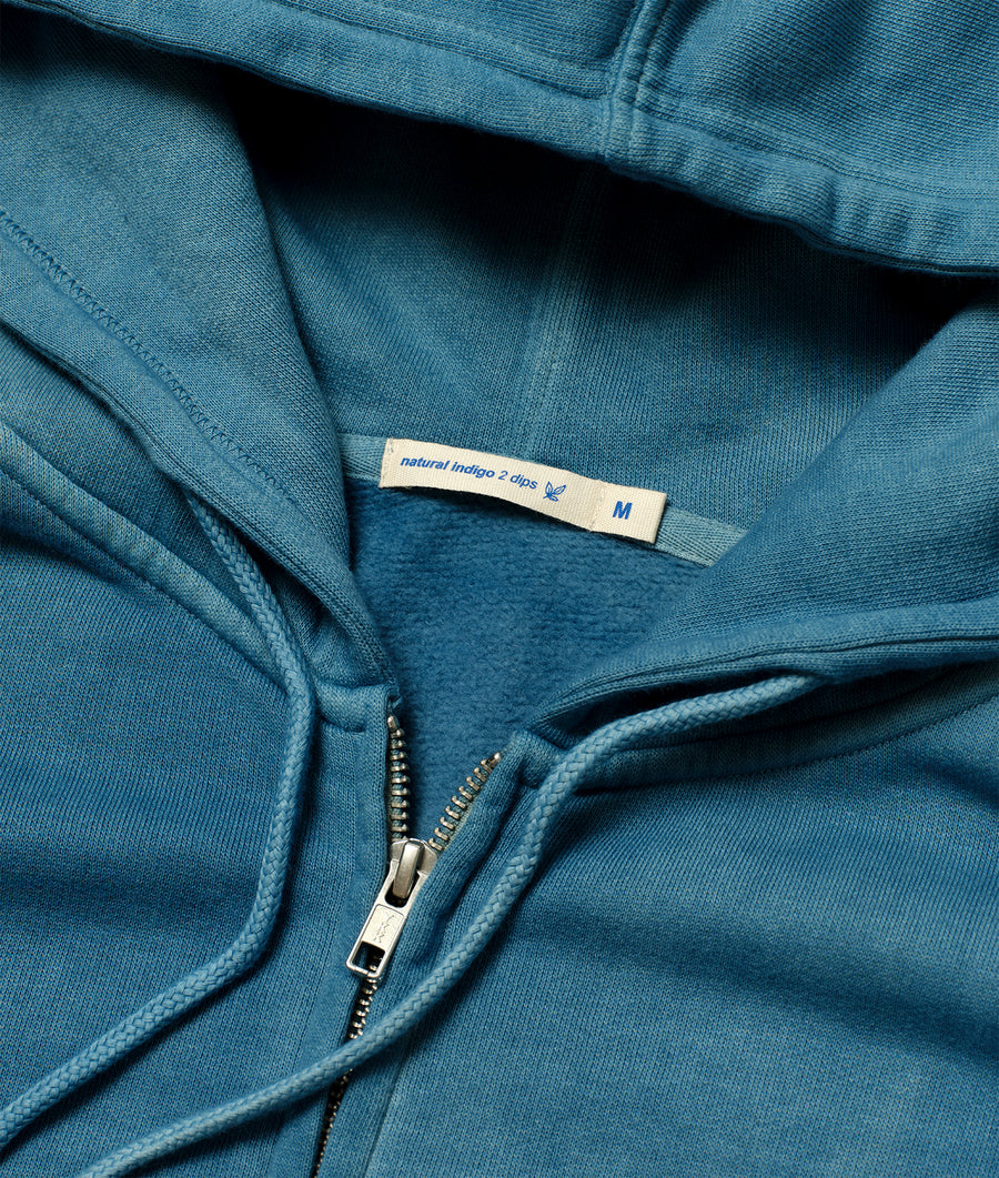 Detail shot of a medium-sized teal blue zip-up hoodie from the Industry of All Nations sustainable apparel brand.