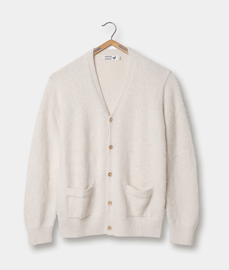 White alpaca cardigan sweater with wooden buttons, hanging on a wooden hanger - Industry of All Nations