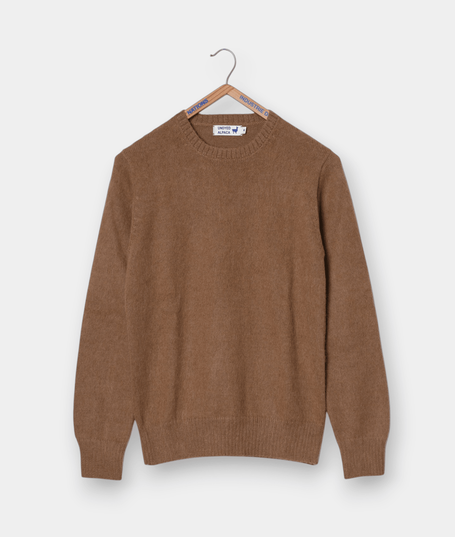 Tan-colored knit sweater on a wooden hanger - Industry of All Nations
