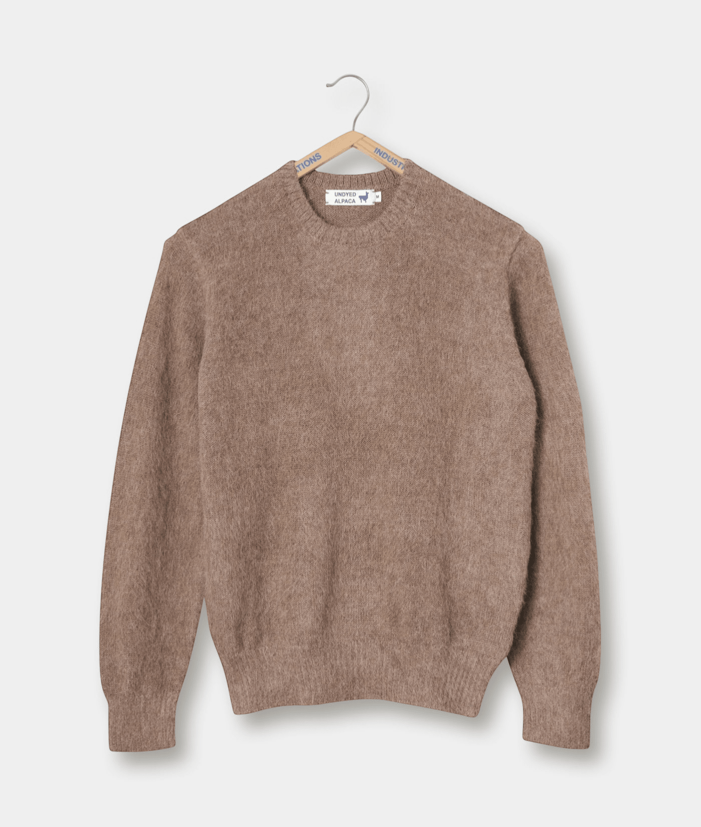 Tan knitted sweater displayed on a hanger - Industry of All Nations