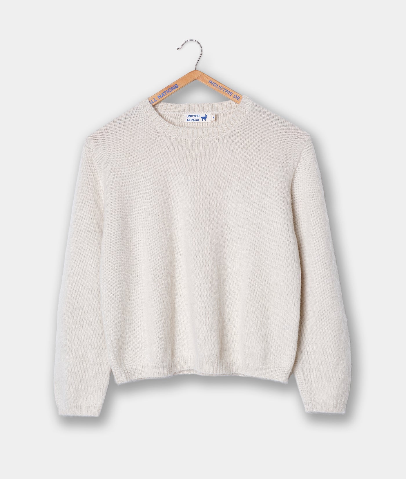 White knit sweater hanging on hanger with Industry of All Nations branding - Industry of All Nations