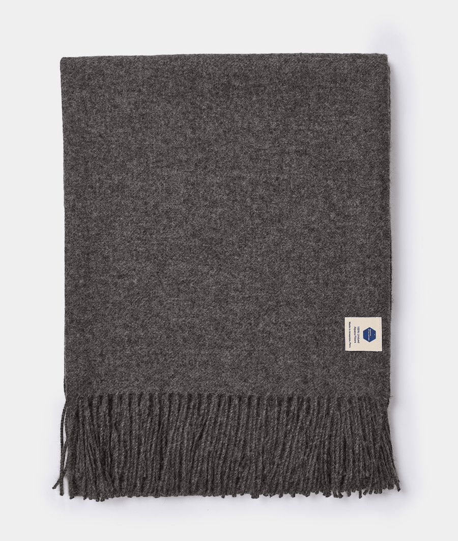 A dark gray alpaca wool scarf with fringe edges, displayed flat against a white background - Industry of All Nations