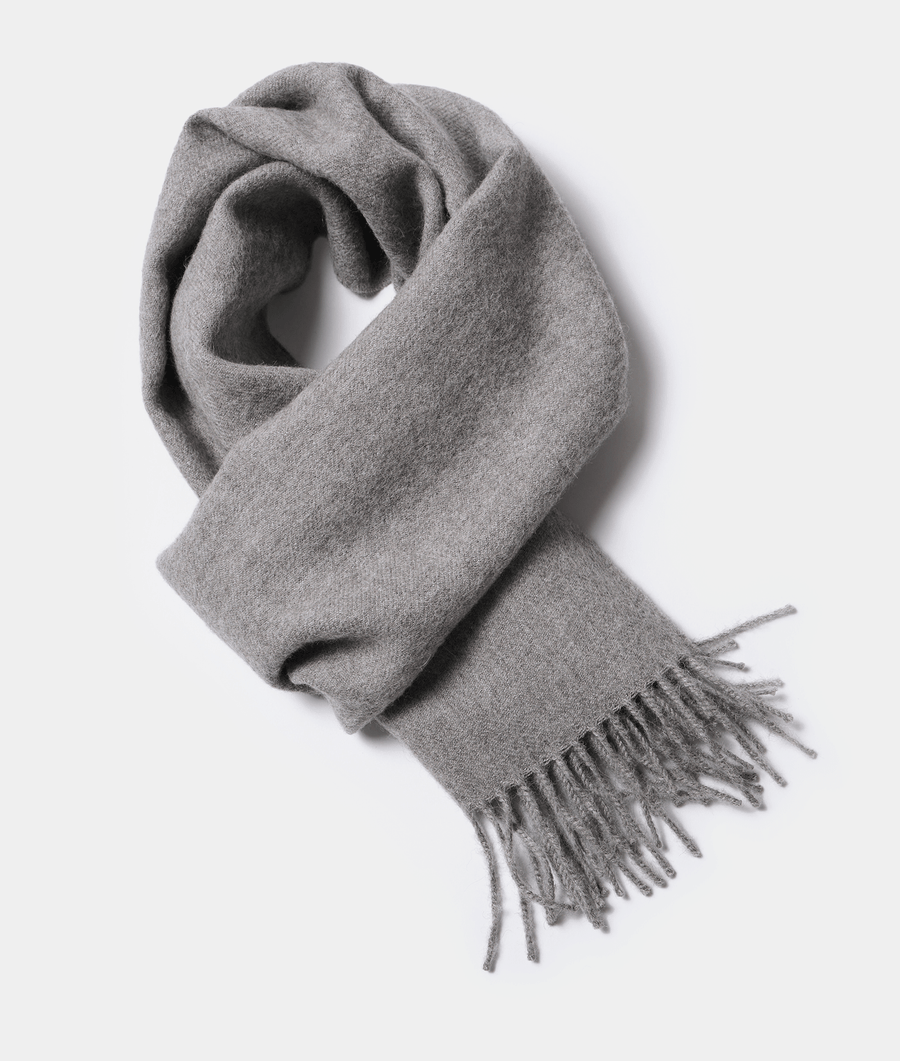 A gray wool scarf with fringed ends, displayed in a flat lay composition - Industry of All Nations